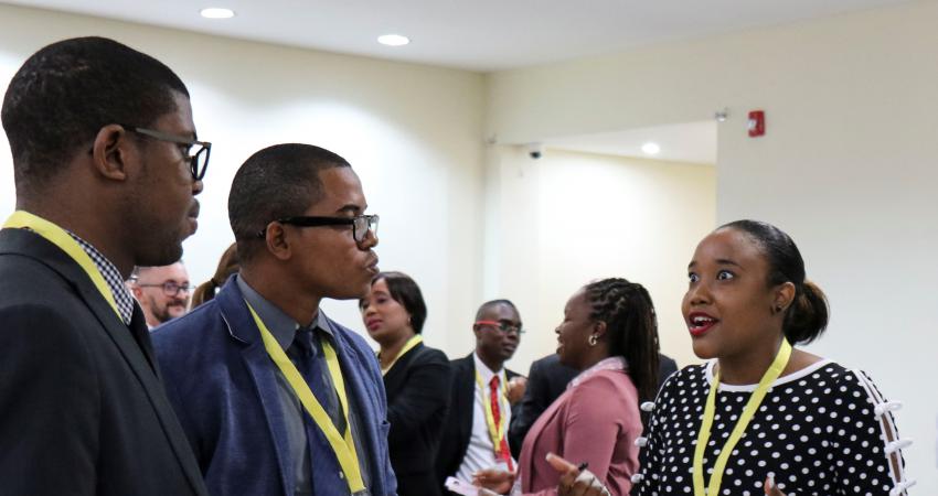 Personas discuten el futuro de Guyana en un ambiente formal (fotos ilustrativas).