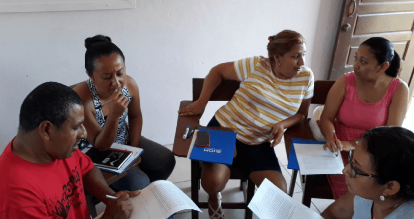 Grupo de 4 personas reunidas trabajando