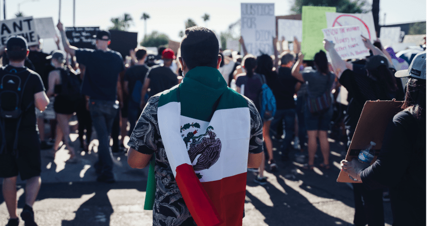 Image of person in a crowd, with a Mexican flag on their back