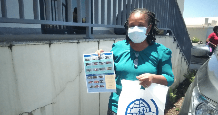 Mujer con mascarilla posa con bolsa de la OIM