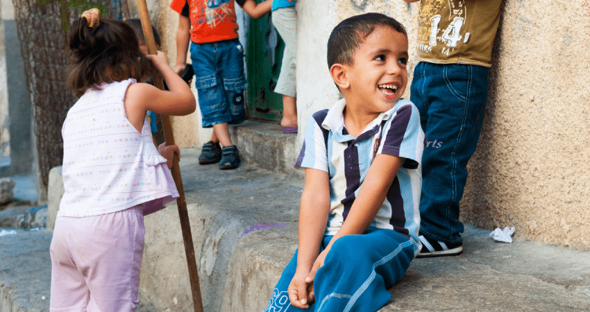 Imagen ilustrativa de niño sentado al borde de la calle.